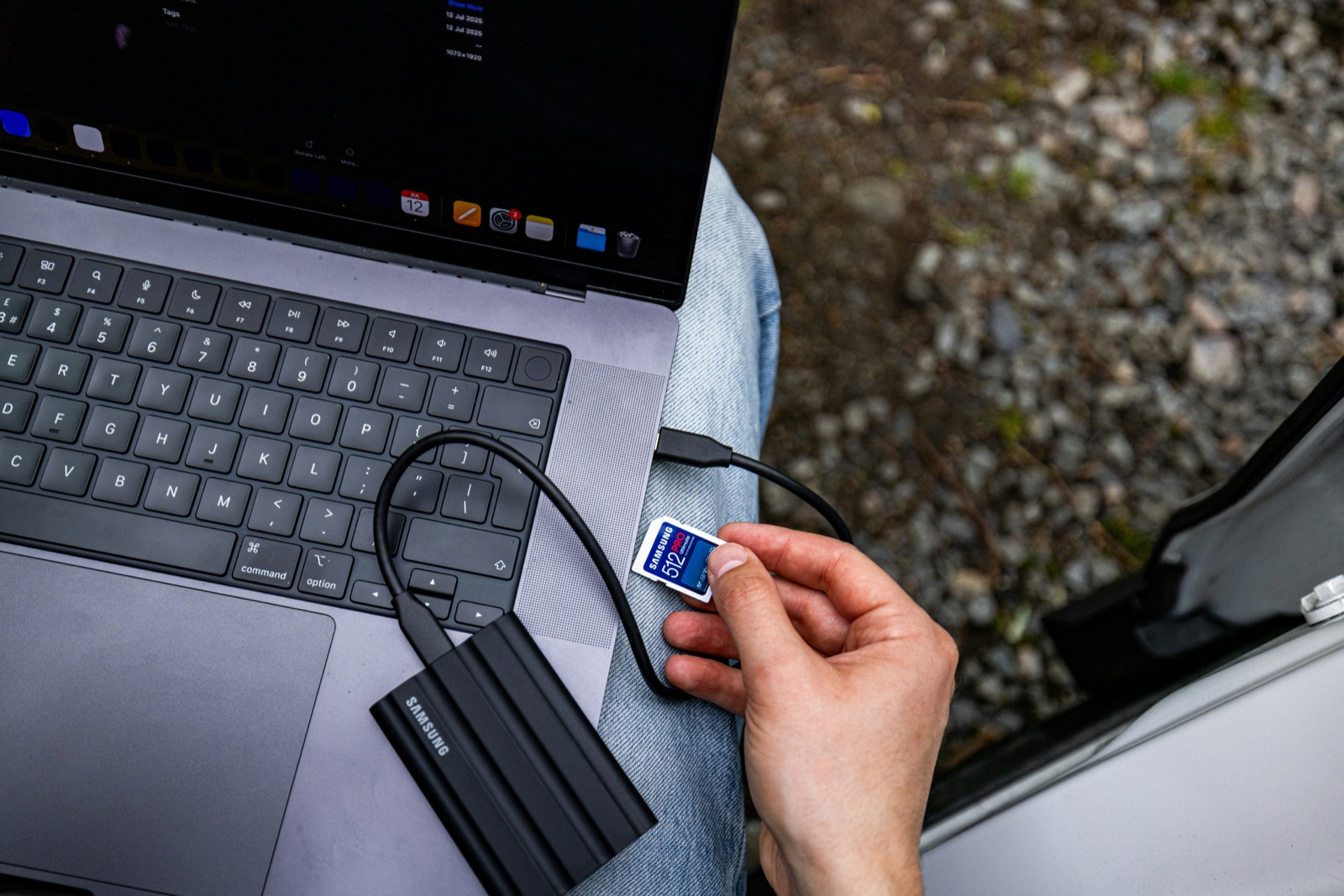 A memory card beside a portable drive connected to a laptop